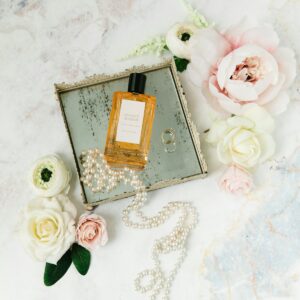 Gold perfume bottle on floral fabric