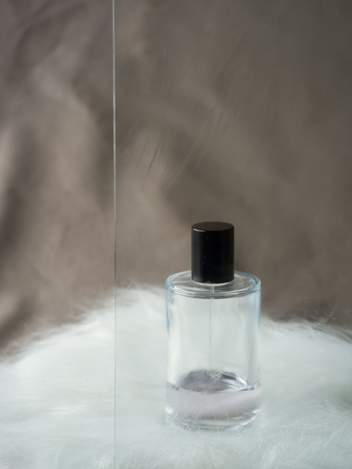 Clear glass perfume bottle with black cap